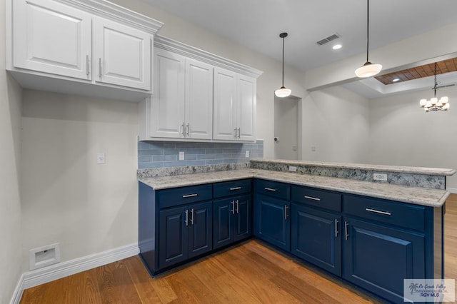 8005 King Sago Ct, Harlingen, TX 78552 - kitchen with blue cabinets, light wood-type flooring, a peninsula, white cabinets, and tasteful backsplash