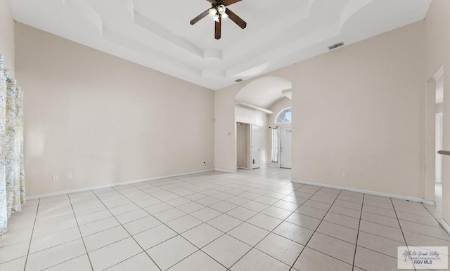 6540 Dockberry Rd, Brownsville, TX 78521 - empty room featuring a ceiling fan, arched walkways, light tile patterned flooring, and a tray ceiling
