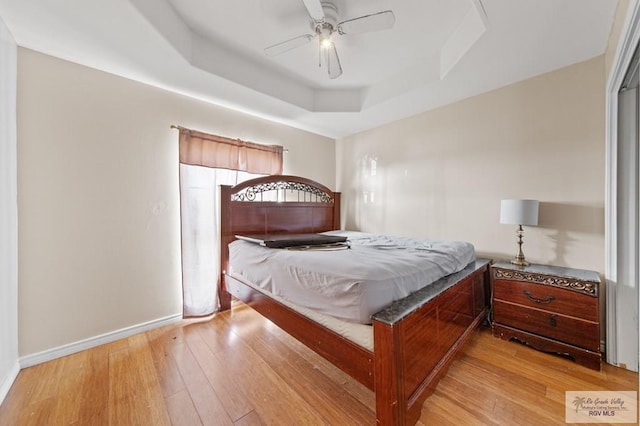 6540 Dockberry Rd, Brownsville, TX 78521 - bedroom with light wood-style floors, a tray ceiling, and ceiling fan