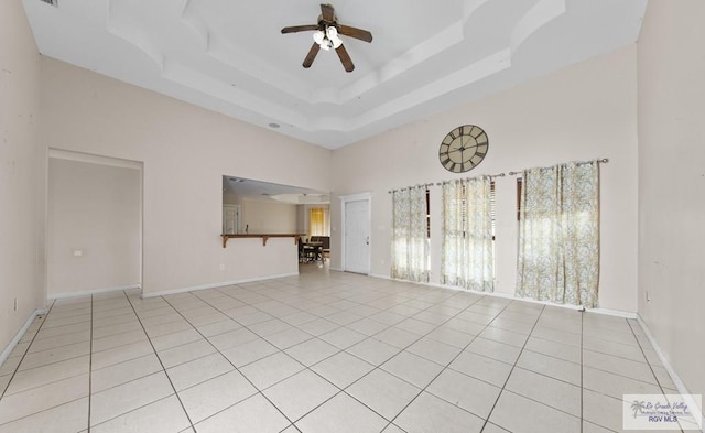 6540 Dockberry Rd, Brownsville, TX 78521 - empty room with a towering ceiling, ceiling fan, light tile patterned floors, and a raised ceiling