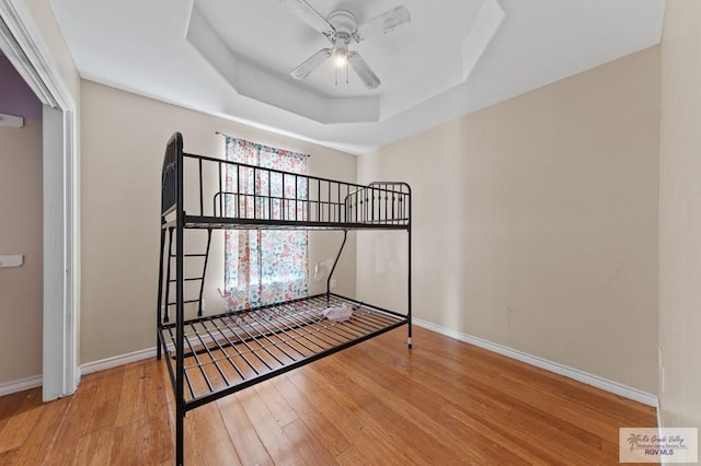 6540 Dockberry Rd, Brownsville, TX 78521 - unfurnished bedroom with wood finished floors, a raised ceiling, and a ceiling fan