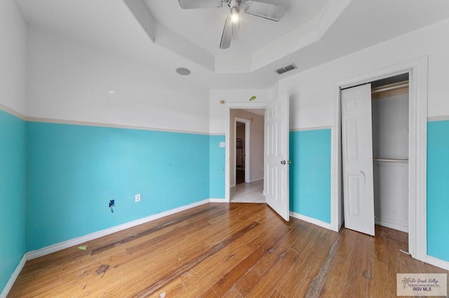 6540 Dockberry Rd, Brownsville, TX 78521 - unfurnished bedroom featuring a raised ceiling, wood-type flooring, a closet, and ceiling fan