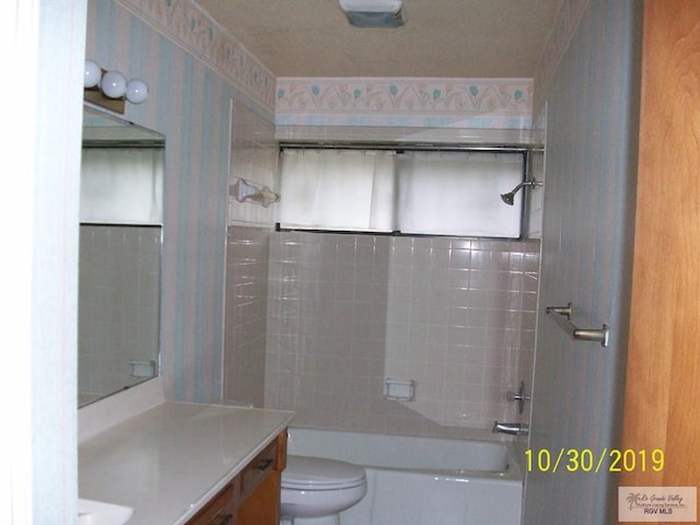 full bathroom with vanity, tiled shower / bath combo, and toilet