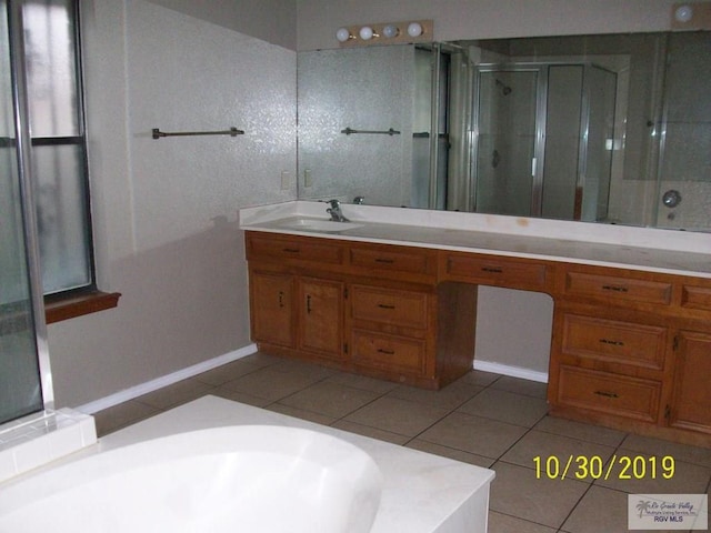 bathroom with tile patterned floors, vanity, and a shower with door