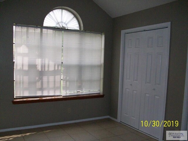 interior space with tile patterned flooring, a healthy amount of sunlight, and vaulted ceiling