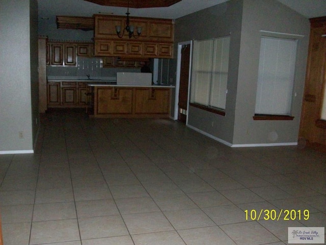 kitchen featuring lofted ceiling, a notable chandelier, and light tile patterned flooring