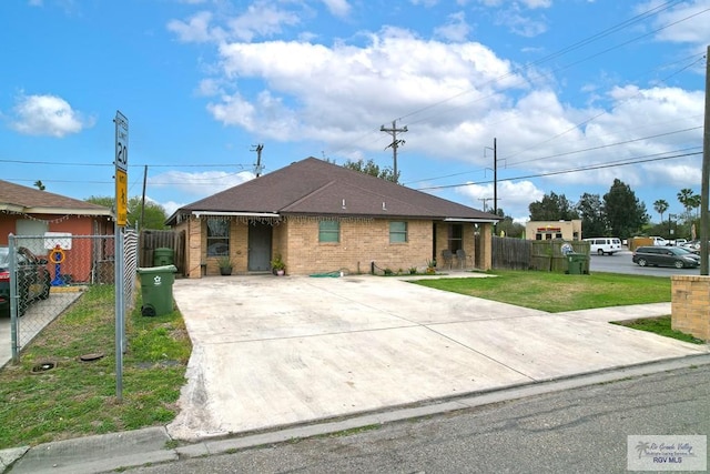 view of front of home with a gate, fence, a front lawn, and brick siding