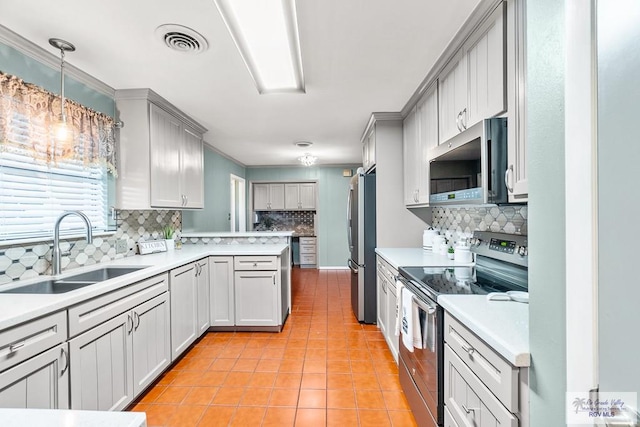 kitchen featuring kitchen peninsula, appliances with stainless steel finishes, sink, light tile patterned floors, and gray cabinets