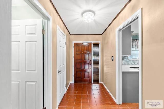 entryway with tile patterned flooring and crown molding