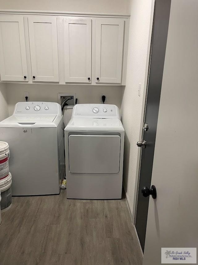 washroom with cabinets, dark hardwood / wood-style floors, and washer and dryer