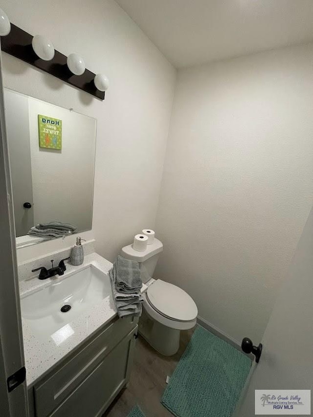 bathroom featuring hardwood / wood-style flooring, vanity, and toilet