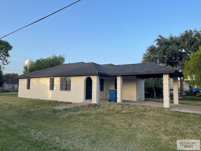 view of front of house with a carport and a front lawn