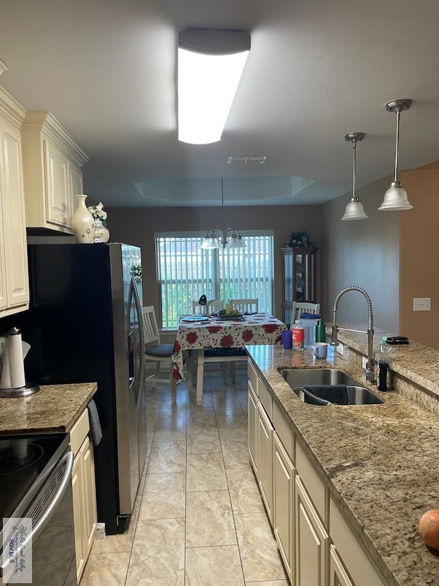 kitchen with sink, light stone counters, stove, a chandelier, and decorative light fixtures