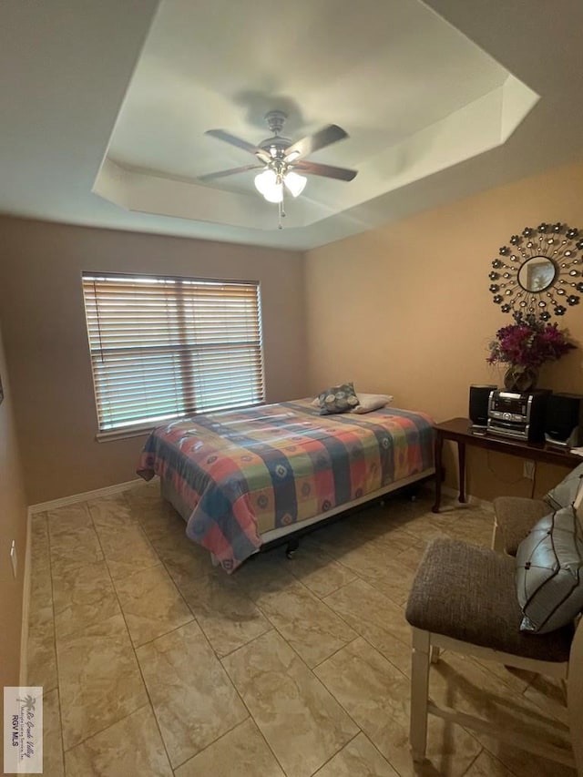 bedroom with a tray ceiling and ceiling fan