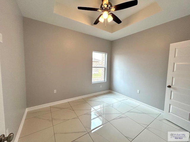 unfurnished room with a raised ceiling and ceiling fan