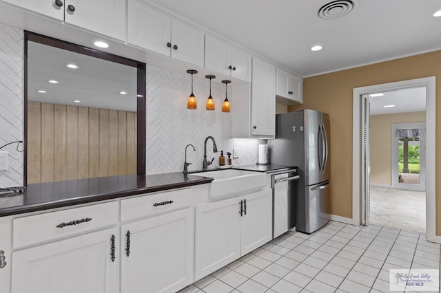 509 Lake Dr, Harlingen, TX 78550 - kitchen with stainless steel appliances, dark countertops, white cabinets, recessed lighting, and tasteful backsplash