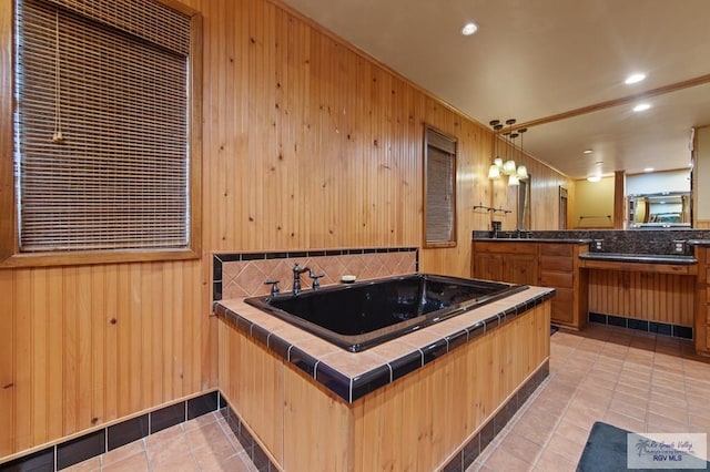 509 Lake Dr, Harlingen, TX 78550 - full bath featuring decorative backsplash, a jetted tub, vanity, wooden walls, and tile patterned floors