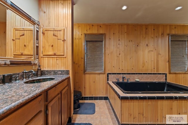 509 Lake Dr, Harlingen, TX 78550 - bathroom featuring vanity, a jetted tub, wooden walls, tile patterned floors, and recessed lighting