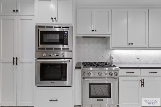 509 Lake Dr, Harlingen, TX 78550 - kitchen with appliances with stainless steel finishes, backsplash, white cabinets, and dark countertops