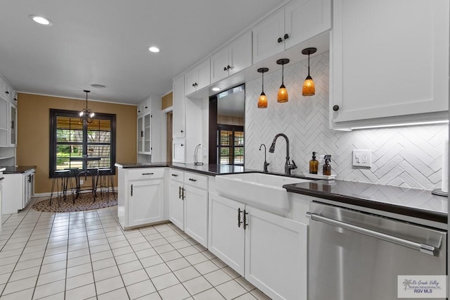 509 Lake Dr, Harlingen, TX 78550 - kitchen with dishwasher, dark countertops, light tile patterned floors, decorative backsplash, and white cabinets
