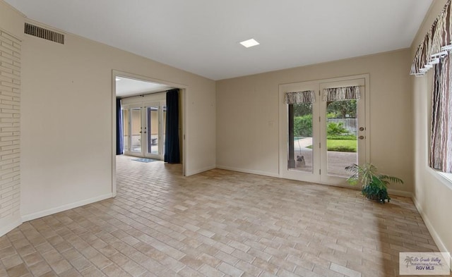 509 Lake Dr, Harlingen, TX 78550 - empty room with plenty of natural light, brick patterned floors, and french doors