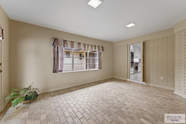 509 Lake Dr, Harlingen, TX 78550 - unfurnished room with brick patterned flooring and brick wall