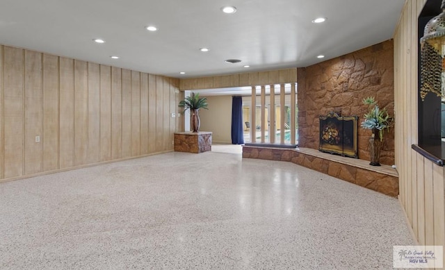 509 Lake Dr, Harlingen, TX 78550 - unfurnished living room with speckled floor, a fireplace, recessed lighting, and wooden walls