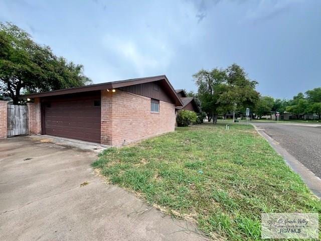105 Fireside Dr, Brownsville, TX 78526 - view of side of property with brick siding, driveway, and a garage