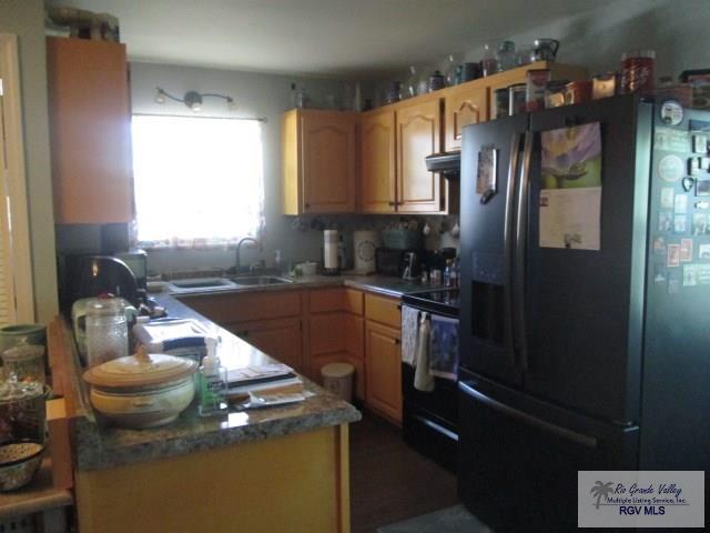 kitchen with sink, ventilation hood, tasteful backsplash, and black appliances