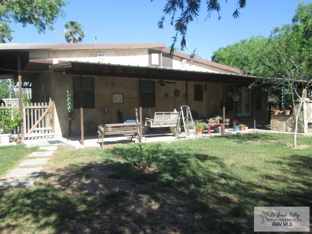 back of house with a yard and a patio area