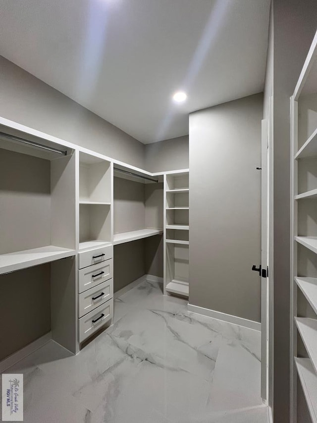 spacious closet featuring marble finish floor