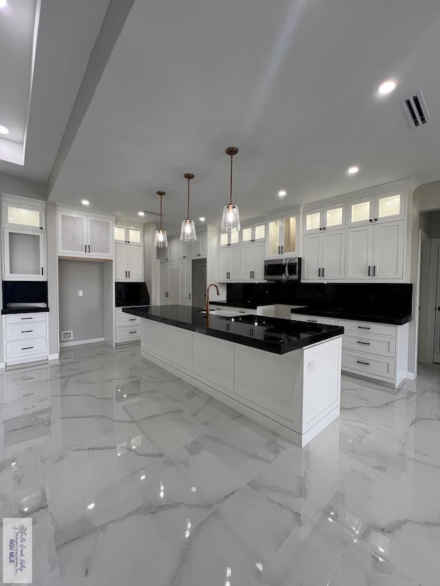 kitchen with marble finish floor, visible vents, and stainless steel microwave