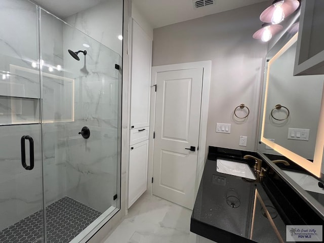 bathroom featuring marble finish floor, a marble finish shower, and vanity