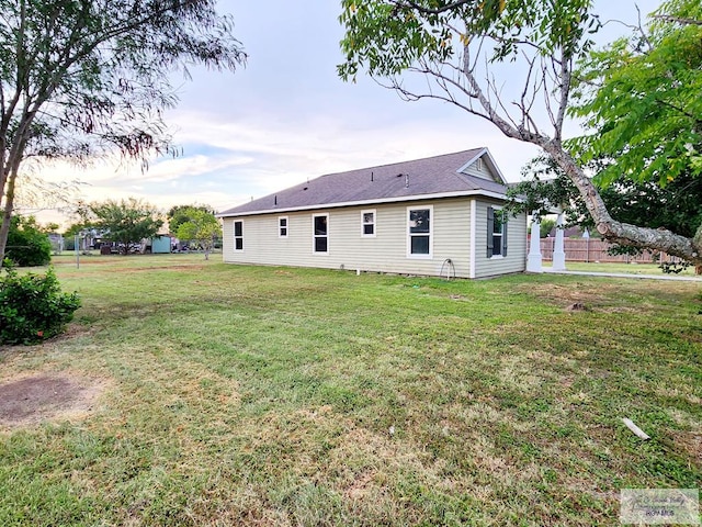 back house at dusk with a lawn