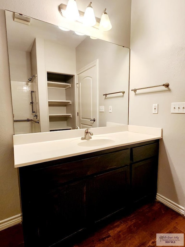 bathroom featuring a shower, hardwood / wood-style floors, and vanity