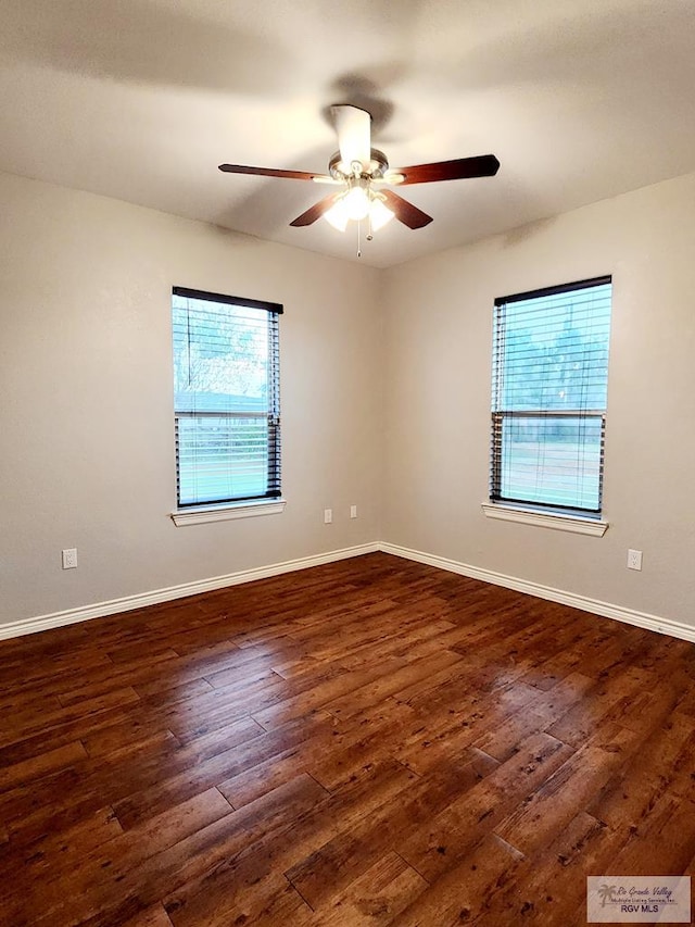 empty room with ceiling fan and dark wood-type flooring