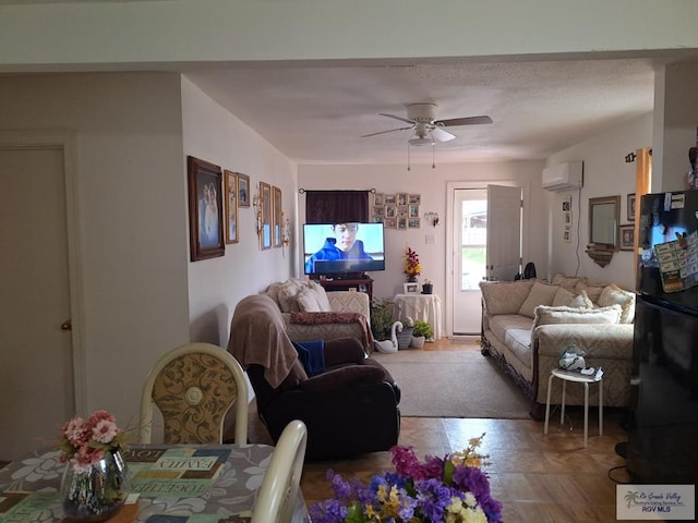 living room featuring ceiling fan and a wall unit AC