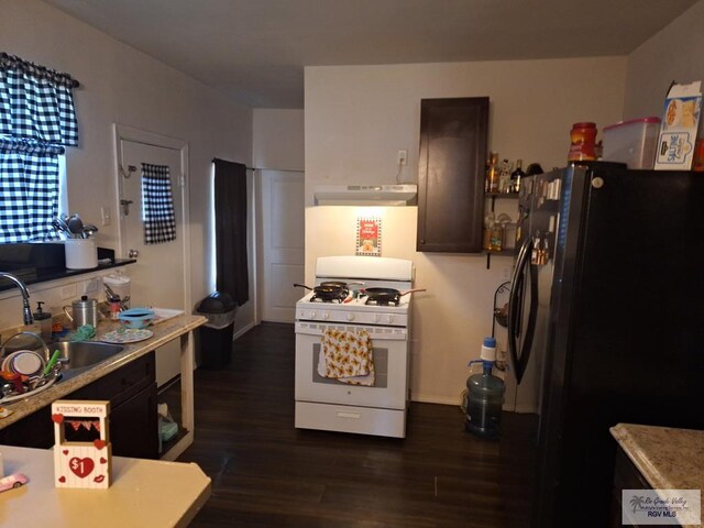 kitchen featuring dark wood-type flooring, black fridge, sink, white gas range oven, and dark brown cabinets