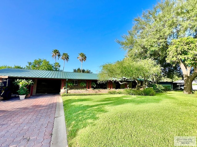 1914 S Parkwood Dr, Harlingen, TX 78550 - view of front of house featuring a front yard, driveway, a metal roof, and a garage