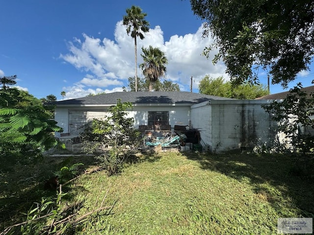 rear view of property featuring a yard