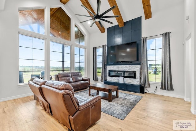 living room featuring beam ceiling, plenty of natural light, high vaulted ceiling, and light hardwood / wood-style floors