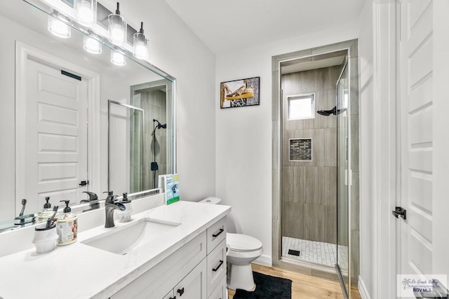 bathroom featuring walk in shower, toilet, vanity, and hardwood / wood-style flooring