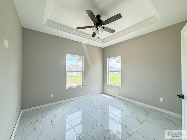 unfurnished room featuring a raised ceiling and ceiling fan