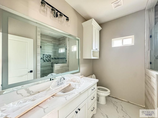 bathroom featuring vanity, toilet, and a shower with shower door