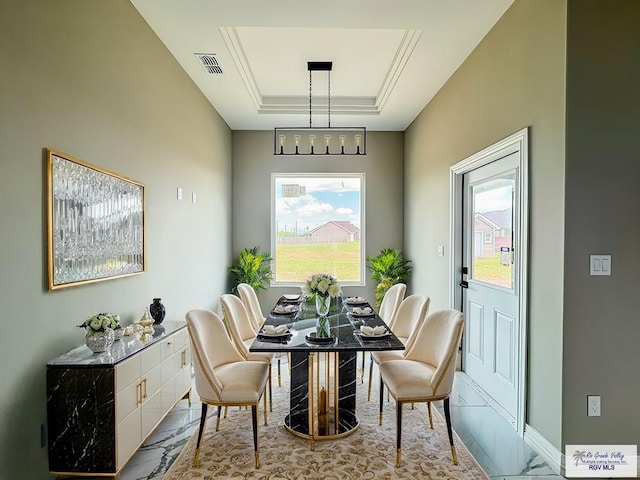 dining area featuring a tray ceiling and a chandelier