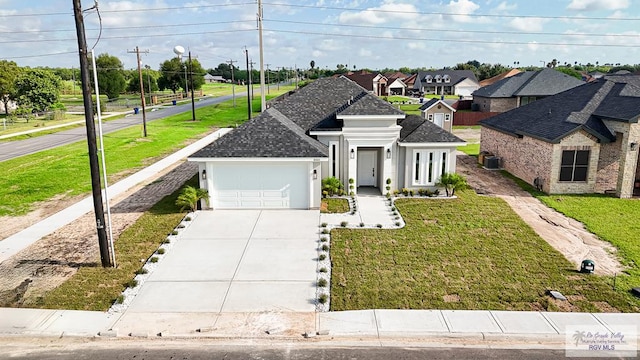 view of front facade with a front yard, a garage, and central air condition unit