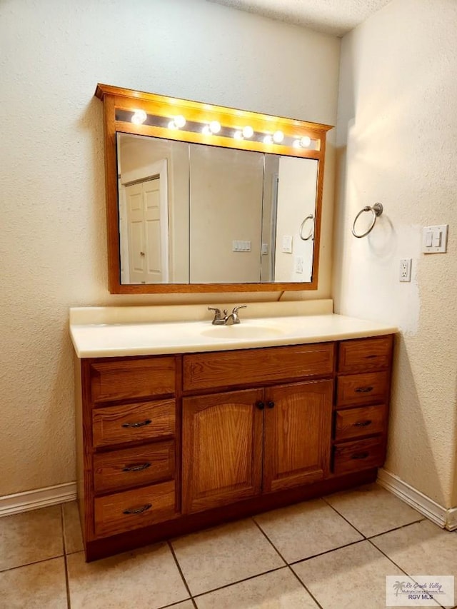 bathroom featuring tile patterned flooring, vanity, and a textured ceiling