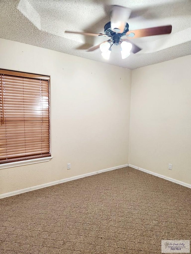 carpeted empty room with ceiling fan and a textured ceiling