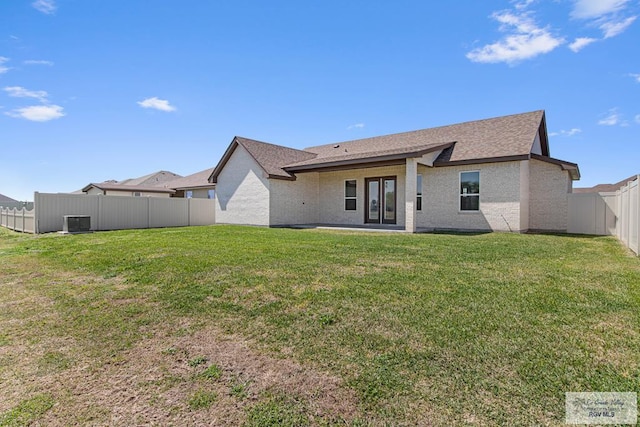 rear view of property with a yard and a fenced backyard