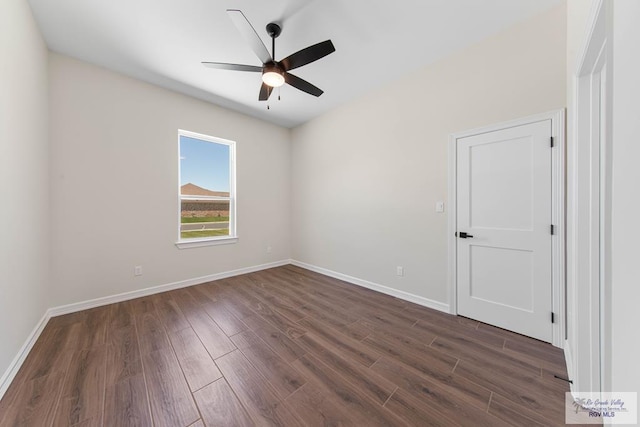 unfurnished room with a ceiling fan, baseboards, and dark wood-style flooring